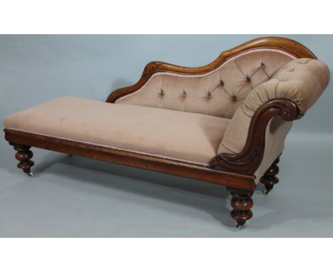 A late Victorian mahogany chaise longue, with shaped serpentine back partially carved with flower heads with button back and 