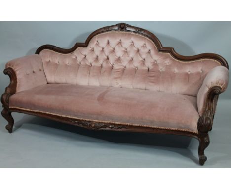 A Victorian mahogany framed scroll arm settee, with shaped back, surmounted by an orb and scroll finial above scroll arms wit