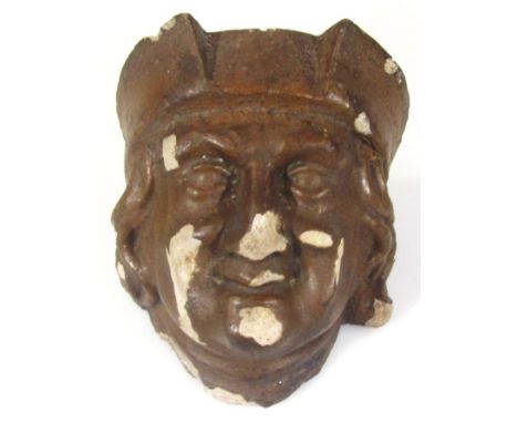 A heavily carved stone terracotta finish drain hopper head wall mask, formed as a smiling gentleman wearing crown, religious 