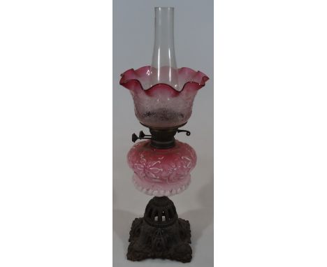 A late Victorian oil lamp, with clear glass funnel, flared etched pink and clear glass shade, moulded glass reservoir and par