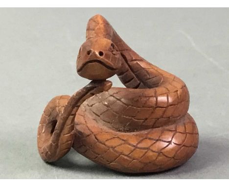COLLECTION OF NETSUKE including a carved box wood example in the form of a coiled snake, a barrel with rats, rabbit and ivori