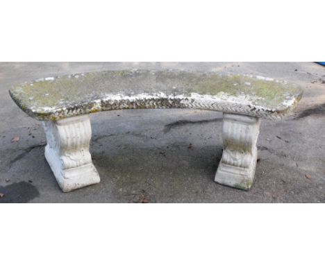 A cast concrete garden bench, curved on scroll supports, 40cm high, 110cm wide, 43cm deep. 