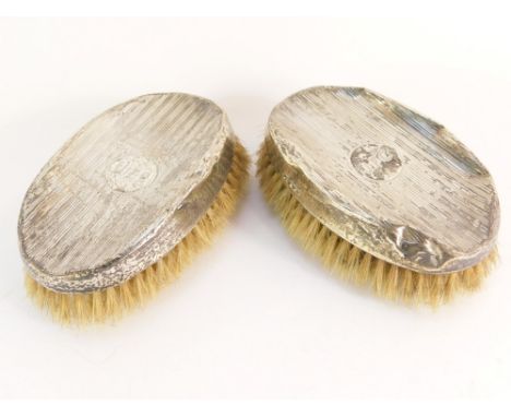 A pair of George V silver backed oval hair brushes, each with engine turned detailing, bearing the initials JFC to circular c