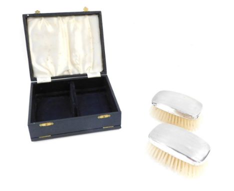 A cased pair of silver backed hair brushes, each with engine turned domed top, Adie Bros Ltd, Birmingham 1949. 