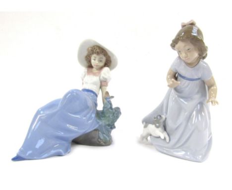 Two Nao porcelain figures, comprising a child and puppy, 15cm high, and a figure of a lady reclined on rock with bird, 15cm h