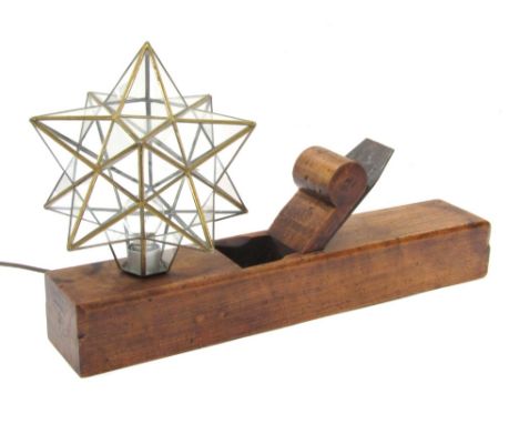 A wooden moulding plane table lamp, with a star shaped glass shade, 58cm long, 10cm wide.