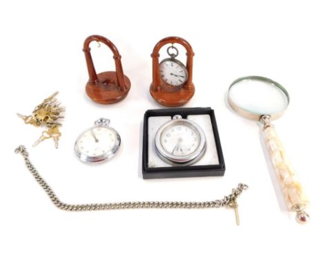 A group of watches and watch stands, comprising a silver fob watch, white enamel dial and Roman numerals, black hands, on two