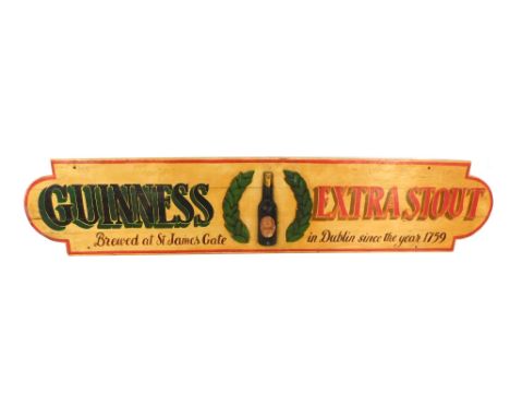 A Guinness Extra Stout wooden pub advertising, with raised relief Guinness bottle in crest, marked James Gate Dublin, since t