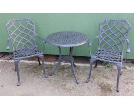 A metal finish garden table, circular on tripod base, with two matched chairs, each of hatched detailing, 71cm high, 64cm dia