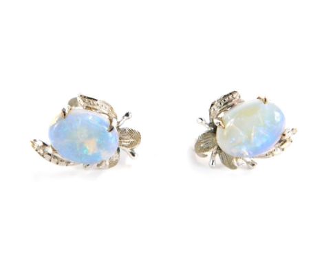 A pair of opal and diamond set spray earrings, each with leaf moulded detailing around an opal, on a white metal backing with