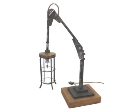 An industrial steel adjustable lamp, with brass lantern fitting, adjustable steel arm and a  wooden base, 60cm high when arch
