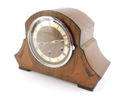A 1950's Art Deco Revival walnut mantel clock, the shaped fan clock with a silver chapter ring bearing Roman numerals and chr