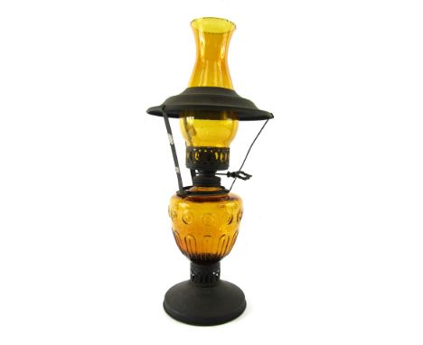 A 1960's/1970's glass oil lamp, with amber glass shade and reservoir, with metal cap supports, 44cm high.