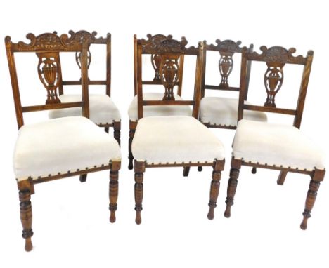 A set of six Edwardian walnut dining chairs, each with a carved harp and floral back, on grey padded seats with studded and r