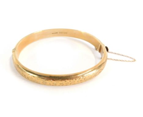 A 9ct gold hinged bangle, each size with engraved detailing and clip clasp, with 9ct gold safety chain, 12.7g all in, 7cm dia