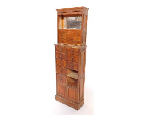 A late 19thC pine shop cabinet, the top section with tambour roll top, opening to reveal boxed interior with marble shelf and