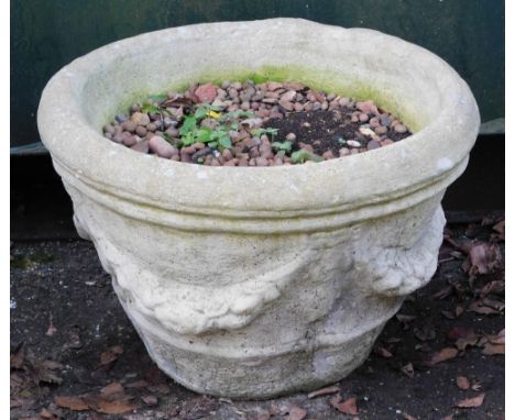 A cast concrete planter, circular with bow drop detailing, 32cm high, 55cm wide. 