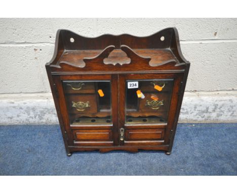 A 20TH CENTURY OAK SMOKERS CABINET, the double doors with bevelled glass panes, that are enclosing a fitted interior, width 4
