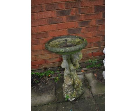 A WEATHERED COMPOSITE WATER FEATURE, in the form of a cherub holding a bowl aloft, with pipe through the centre, height 63cm,