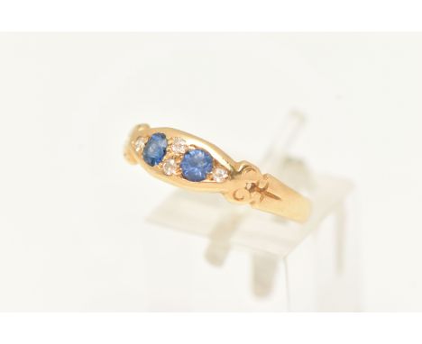 AN EARLY 20TH CENTURY SAPPHIRE AND DIAMOND BOAT RING, set with two oval cut blue sapphires and four old cut diamonds, scrolli