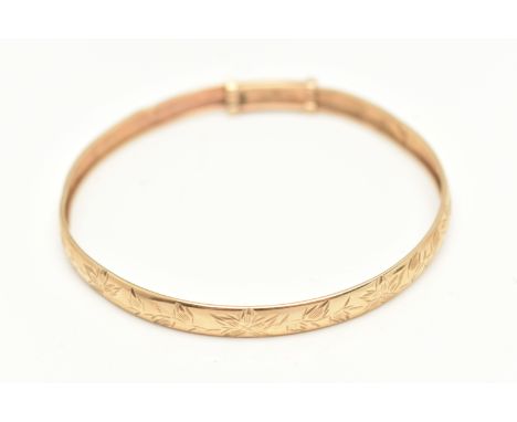 A YELLOW METAL BANGLE, decorated with a foliate pattern, unmarked metal, approximate internal diameter 71.0mm, approximate gr