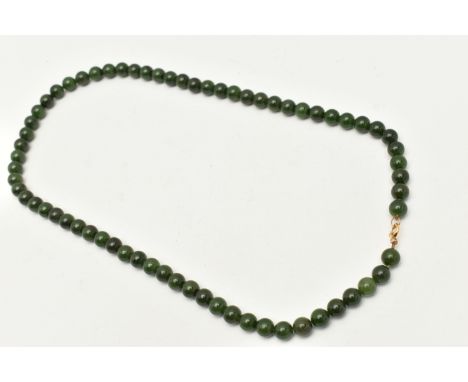 A NEPHRITE BEAD NECKLACE, single strand of polished nephrite beads, approximately 8.4mm each, fitted with a yellow metal spri