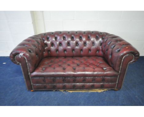 A OXBLOOD LEATHER CHESTERFIELD TWO SEATER SOFA, length 165cm, condition report: crack in multiple places, and tear to the lef