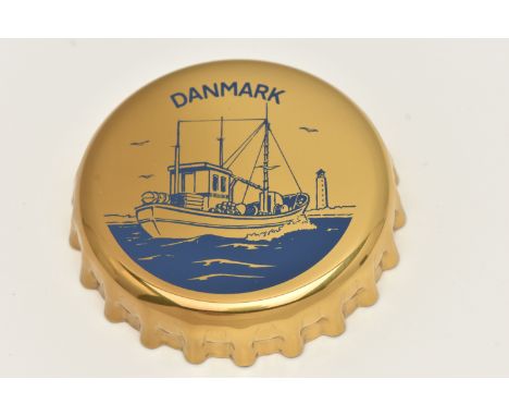A GEORG JENSEN NOVELTY BOTTLE OPENER, designed as a bottle top with a blue ship and 'Danmark' detail to the top, stamped 1981