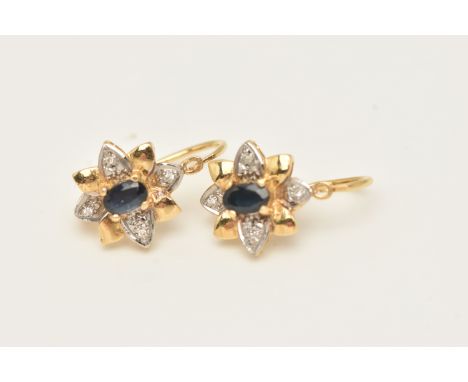 A PAIR OF YELLOW METAL GEM SET EARRINGS, each of a flower shape set with a central oval cut deep blue sapphire, with colourle