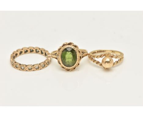 THREE RINGS, to include a yellow metal full spinel eternity ring, stamped 9.375, ring size L 1/2, a green tourmaline ring, an