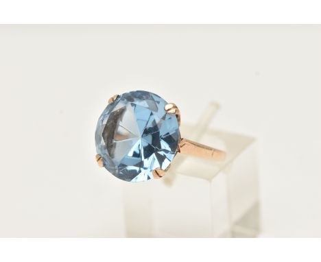A 9CT GOLD BLUE TOPAZ RING, set with a large circular cut blue topaz, measuring approximately 15.6mm diameter, in a double fo