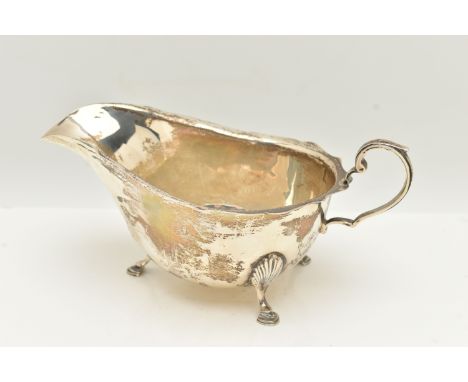 A EDWARD VIII SILVER GRAVY BOAT, polished form with wavy rim, raised on three hoof feet and fitted with a scrolling handle, h