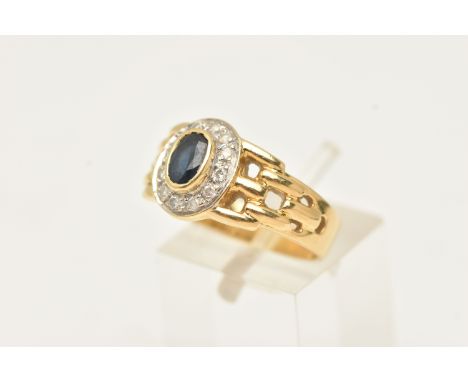A YELLOW METAL SAPPHIRE AND DIAMOND RING, set with a central oval cut deep blue sapphire, within a round brilliant cut diamon