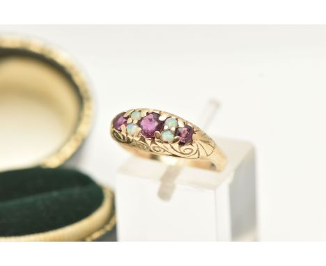 A 9CT OPAL AND RUBY RING, set with three circular cut rubies and four small opal cabochons, scrolling gallery leading onto a 