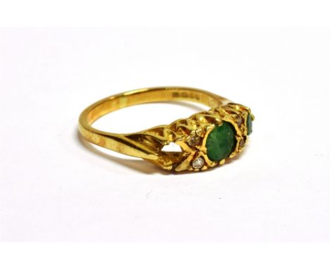 AN 18CT GOLD, EMERALD AND DIAMOND BOAT-SHAPED RING the two (of three) round mixed-cut emeralds spaced by pairs of small eight