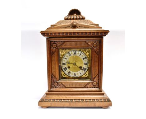 A CONTINENTAL MANTLE CLOCK  the 8-day Junghans movement striking on a coiled gong, in a carved walnut architectural case, 33c