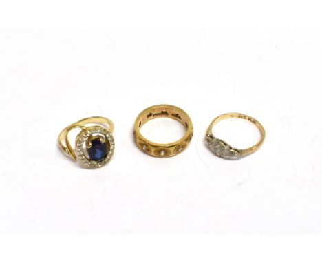 THREE MODERN 9CT GOLD AND GEM SET RINGS comprising; an oval mixed-cut dark-blue synthetic-sapphire and cubic zirconia oval cl