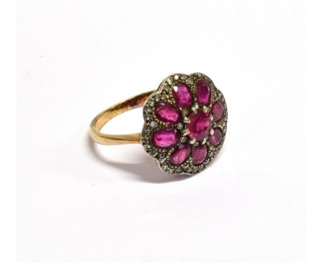 A RUBY AND DIAMOND FLOWER-HEAD CLUSTER RING with a central round mixed-cut ruby within an octofoil surround of eight oval mix