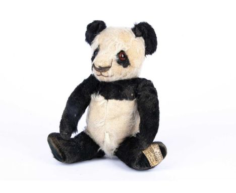 A Merrythought panda Teddy Bear, 1939,  with black and white mohair, orange and black glass eyes, pronounced muzzle with blac