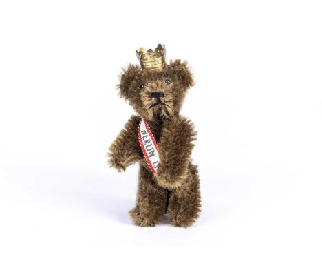 A post-war Schuco Berlin Teddy Bear lapel pin,  with brown mohair, black pin eyes, black stitched nose and mouth, metal frame