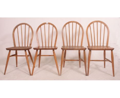 A set of 4 1970's Ercol golden dawn stick back dining chairs in beech and elm with saddle seats and arched back rests. Measur