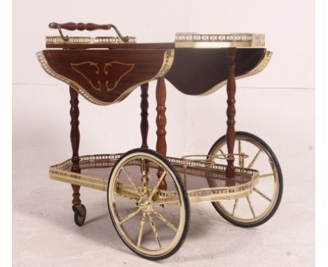 A vintage 20th century  Italian floral marquetry effect 2 tier drinks trolley, having brass bottle holders and drop leaf side
