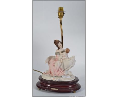 A 20th century Naples ceramic / Capodimonte porcelain table lamp raised on a wooden plinth base. Measures: 42cm H.