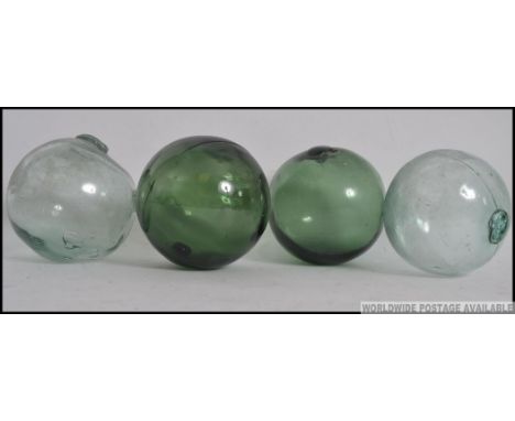 Four 20th century vintage glass fishing floats, two green along with two others. Measures: 13cm.