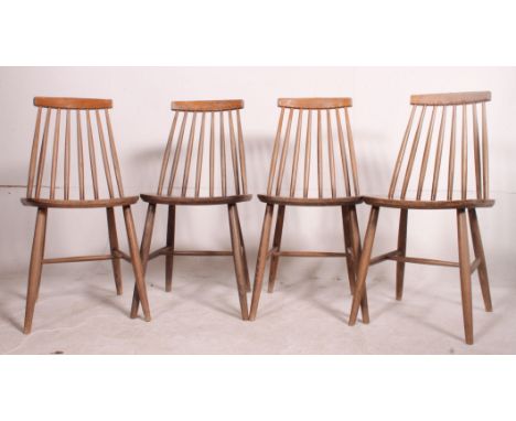 A set of 4 retro Ercol style stick back dining chairs with saddle seats raised on turned legs united by stretchers. Measures: