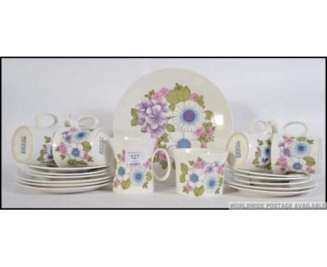 A Retro floral patterned 6 person service by Angelique  comprising of cups, saucers,creamer , sugar bowl etc..