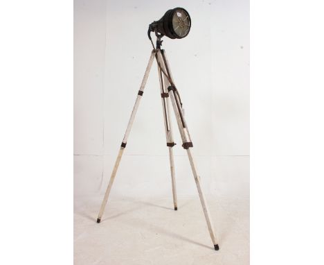 A vintage 20th century theatre / cinema external spot lamp raised on a painted shabby chic wooden tripod. Measures: 145cm x 5