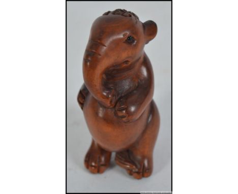 A hard wood Japanese ornately carved Netsuke of a standing elephant. 