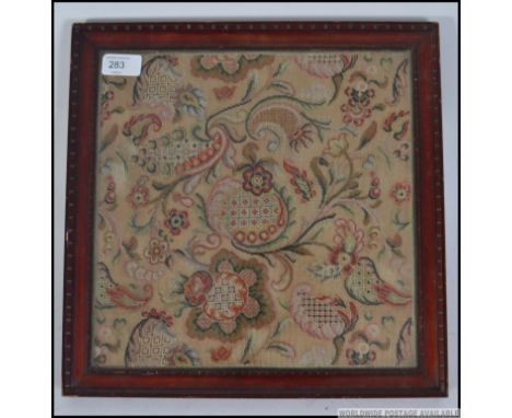 A framed and glazed 19th century tapestry sampler, of floral geometric design. Measures: 30cm x 30cm.