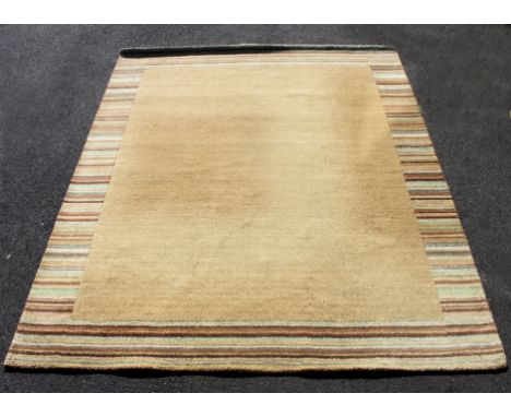 A large late 20th century good quality contemporary floor rug of deep pile construction in beige / light tone colours. Measur